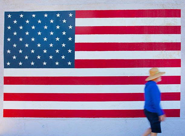 USA Arizona Tucson    man walking past a america flag on wall.