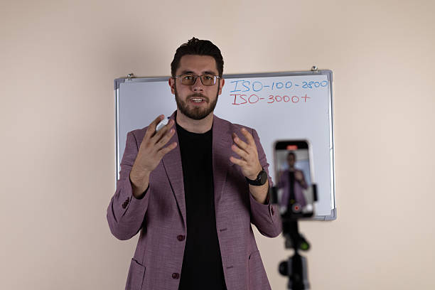 istock Male tutor or vlogger explaining material on a whiteboard in a studio 2251309946