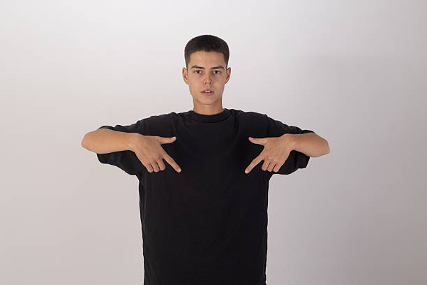 istock Young man in black t-shirt adjusting his collar, casual pose 2251310234