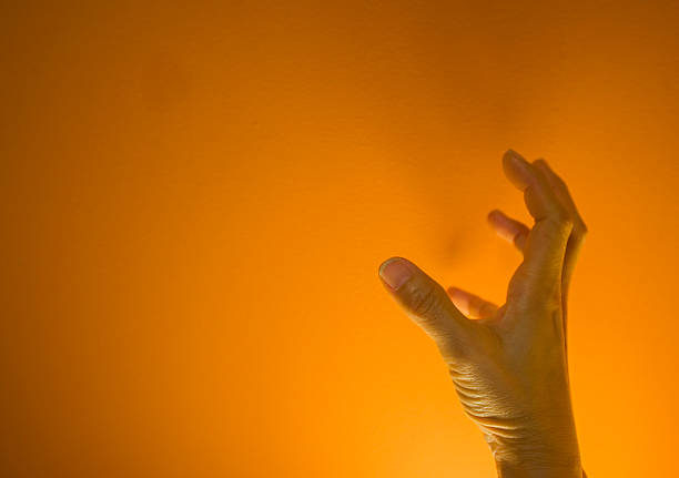 Skeleton hands holding an orange background
