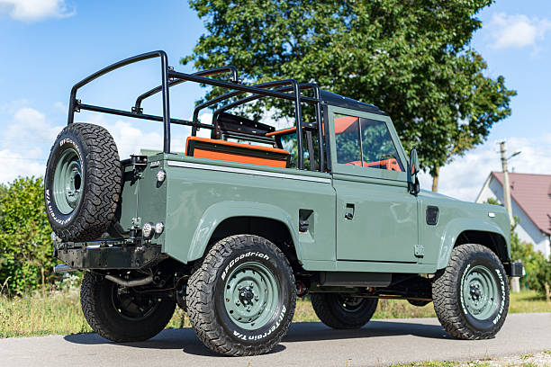 Vilnius, Lithuania - September 24, 2025: A restored and custom built Land Rover Defender 90 with a Soft Top. Repainted in Land Rover green colour, custom soft top made from mohair. Wolf style wheels with more aggressive tires. Defender 90 is a two door short wheel base version.