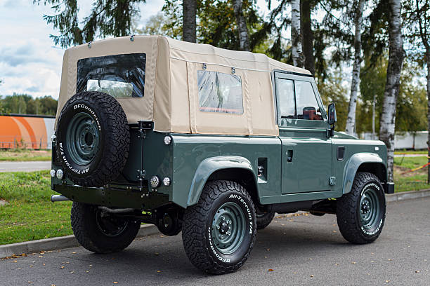Vilnius, Lithuania - September 24, 2025: A restored and custom built Land Rover Defender 90 with a Soft Top. Repainted in Land Rover green colour, custom soft top made from mohair. Wolf style wheels with more aggressive tires. Defender 90 is a two door short wheel base version.
