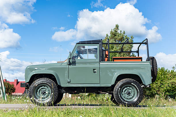 Vilnius, Lithuania - September 24, 2025: A restored and custom built Land Rover Defender 90 with a Soft Top. Repainted in Land Rover green colour, custom soft top made from mohair. Wolf style wheels with more aggressive tires. Defender 90 is a two door short wheel base version.