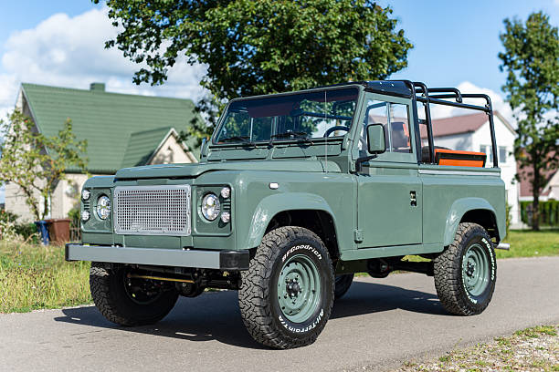 Vilnius, Lithuania - September 24, 2025: A restored and custom built Land Rover Defender 90 with a Soft Top. Repainted in Land Rover green colour, custom soft top made from mohair. Wolf style wheels with more aggressive tires. Defender 90 is a two door short wheel base version.