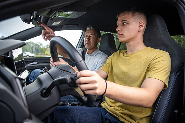 istock Experienced Instructor Guiding Teenager Driver in Modern Car Interior 2251314382