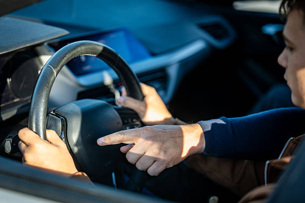 istock Driving Instructor Demonstrating Steering Wheel Controls in a Modern Car Interior 2251314409