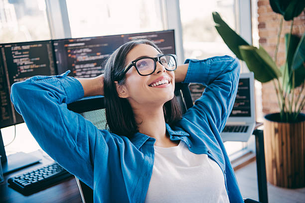 istock Happy woman programmer at modern loft office smiling with monitors and plant 2251316602