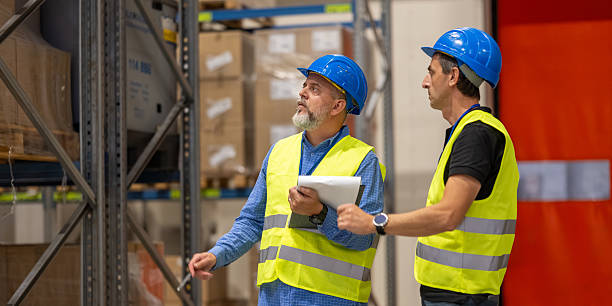 istock Two Warehouse Workers Discussing Inventory with Clipboard 2251317310