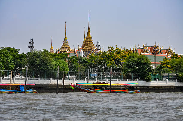 istock Dramatic Contrast in Architecture: Old Waterfront Homes and Dilapidated Buildings Against Modern Skyscrapers and Luxury Condos on the Chao Phraya River in Bangkok, Thailand 2251320136