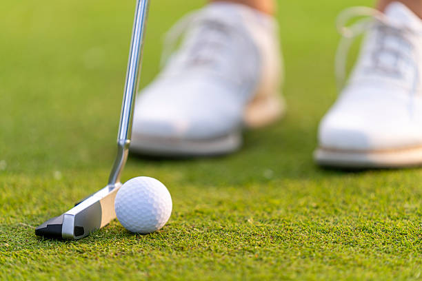 istock Focused Female Golfer Aligning Putt on Green with Precision and Determination 2251320337