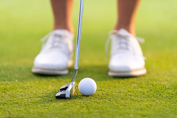 istock Focused Female Golfer Aligning Putt on Green with Precision and Determination 2251320344