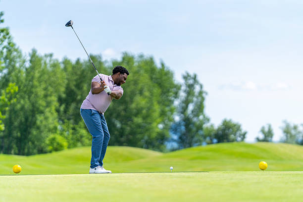 istock Young Hispanic Male Golfer Swinging Driver with Focus on Lush Green Course 2251320449