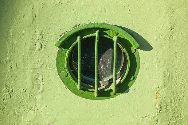 istock Barred porthole on green old ship's wall, Germany, Europe 2251320853