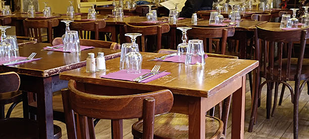 A typical Lyonnais bistro dining room with rustic wooden tables and traditional seating