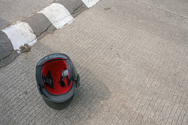 Safety First Motorbike Helmet Resting on Textured Road Surface