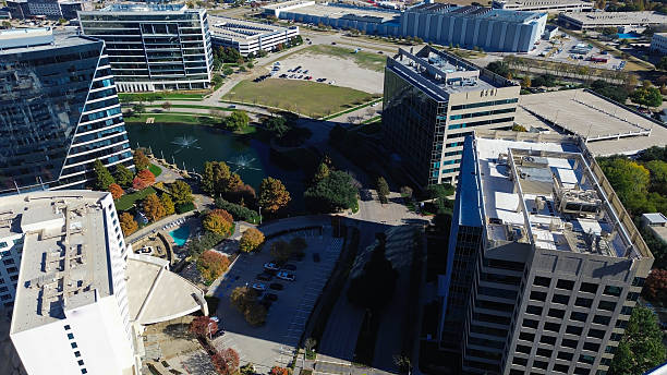 istock Triangle pool in urban hotel paired with nearby office complexes, rooftop mechanical systems, landscaped pond, fountains, sidewalk blending hospitality with corporate infrastructure, Plano, TX 2251324332