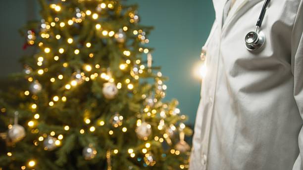 istock Doctor Wishes Patients a Merry Christmas with Glowing Tree Background Copy Space 2251325763