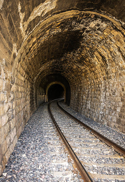 istock Railway Tracks Leading Through a Dark Train Tunnel 2251326908