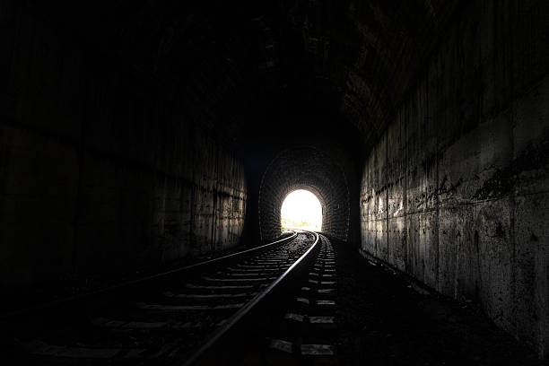 istock Railway Tracks Leading Through a Dark Train Tunnel 2251326916