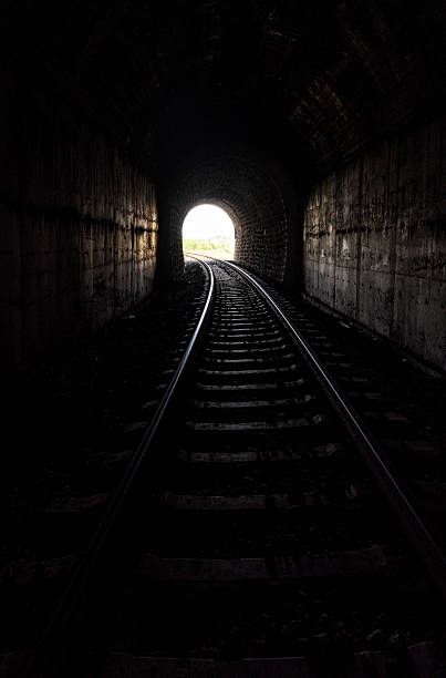 istock Railway Tracks Leading Through a Dark Train Tunnel 2251326926