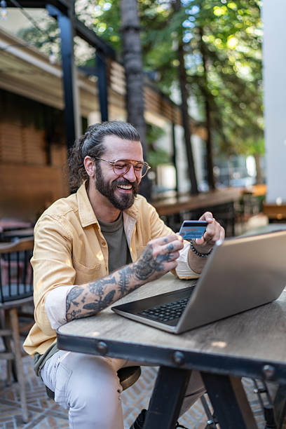 istock Smiling man making online payment with credit card 2251328238