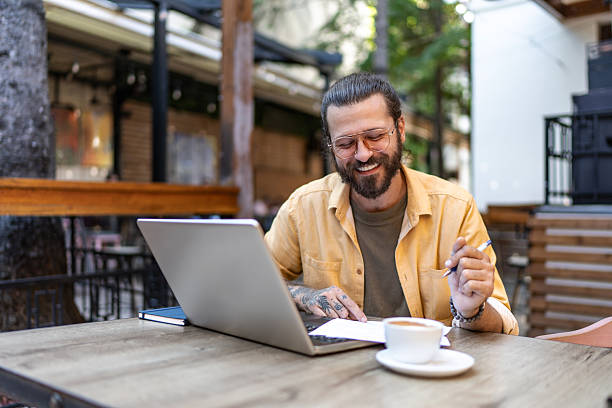 istock Bearded man working remotely at outdoor cafe 2251328449