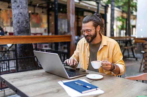 istock Man working on laptop at outdoor cafe 2251328654