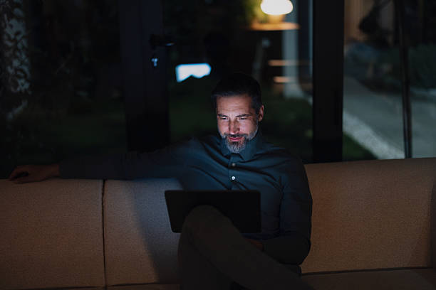 istock Man Works Late on Laptop on Couch in Evening Home Office, Night Shift 2251332223