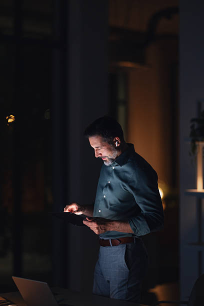 istock Focused Businessman Working Late At Night On Tablet In Modern Office 2251332311