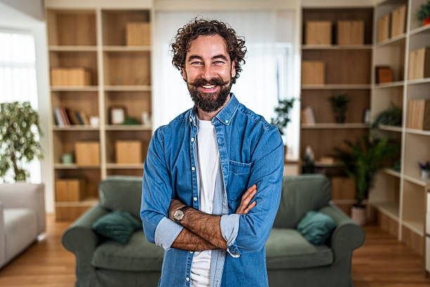 istock Smiling confident man standing at home living room 2251341293
