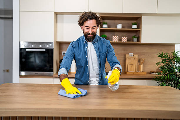 istock Happy man cleaning kitchen counter at home 2251341530