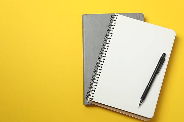 istock PNG, Notepads with pens, isolated on yellow background 2251342068