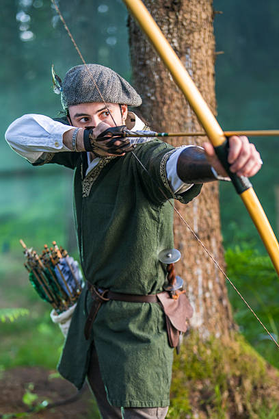 istock Young Caucasian Archer Focused on Target in Forest Setting with Intense Concentration 2251342498