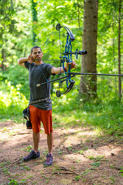 istock Focused Caucasian Male Archer Aiming Bow with Determination in Dense Forest Setting 2251342629