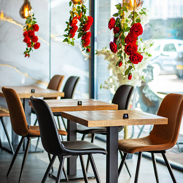 A beautifully designed restaurant interior showcasing a modern and elegant dining area. The space features contemporary furniture, including wooden chairs and tables set with glassware, plates.