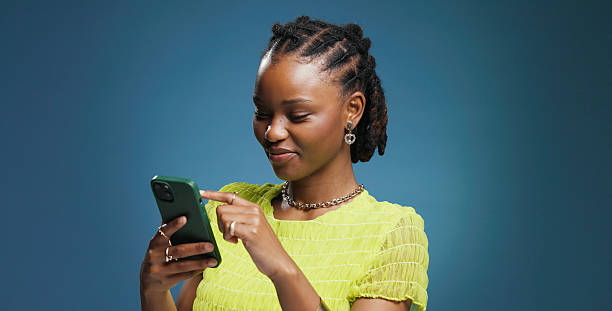 istock Typing, smartphone and black woman in studio, internet and communication on blue background. Mockup space, mobile user and African person with cellphone, network and message to contact, app and email 2251344084