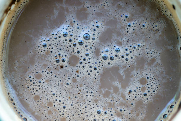 This close-up image captures the creamy foam and bubbles on top of a delicious cup of coffee. Perfect for illustrating beverage culture or coffee enjoyment.