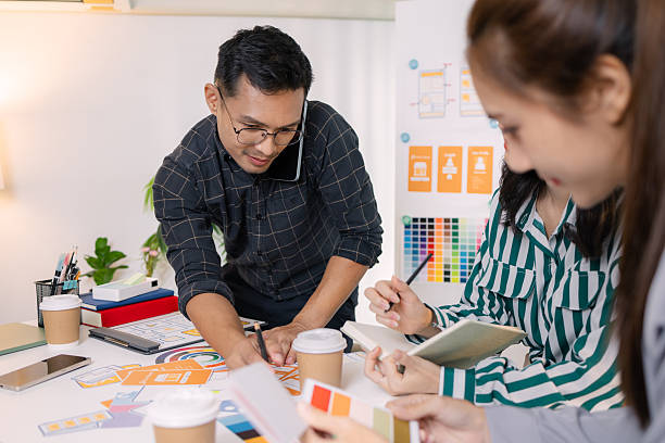 istock UX/UI designers presenting their final design project to the team, showcasing app interface screens and explaining user experience strategies in a professional creative office environment. 2251346548