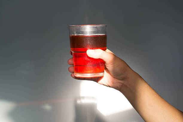 istock Hand Holding Glass of Hot Tea in Dramatic Sunlight 2251347800