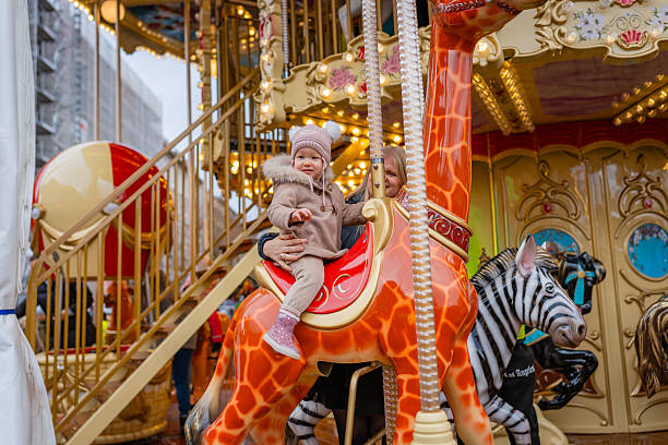 istock Toddler Riding Carousel Giraffe at Holiday Fair 2251348020