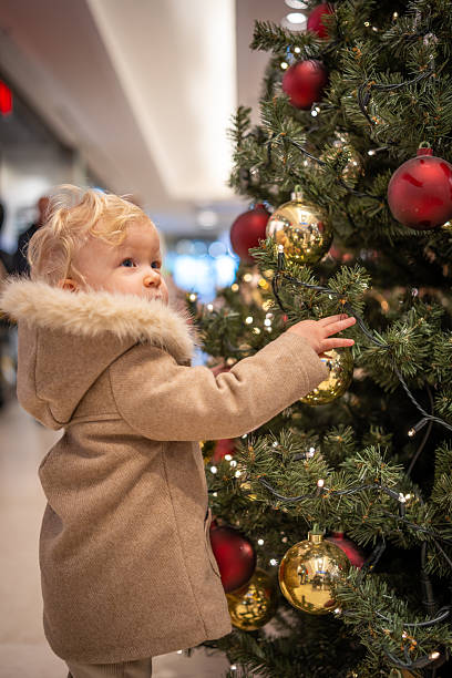 istock Toddler Reaching Toward Christmas Tree Ornaments Indoors 2251348099