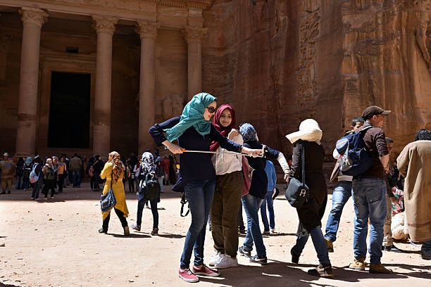 Petra, Jordan - Apr 1, 2015: Unidentified Jordanian young girls make selfie in front of the Petra's temple to put a picture in social media after. Selfie is a craze, which gripped the whole World