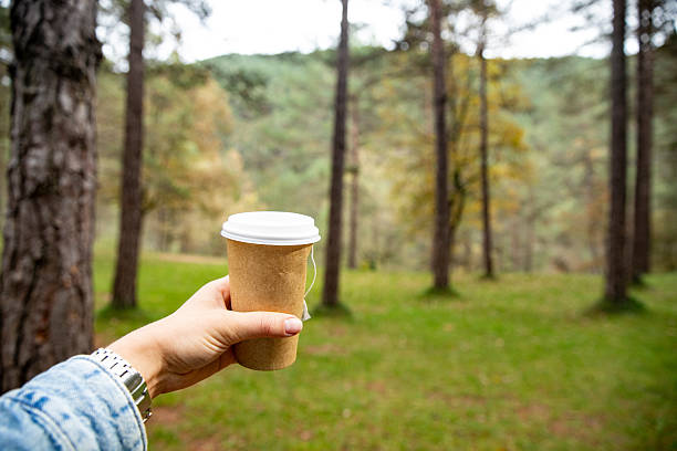 istock A hand holds a takeaway coffee cup on a walk, outdoors in a park or forest 2251349558