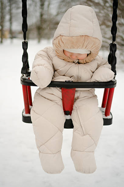 istock Curious baby experiencing winter fun on snowy swing 2251350893