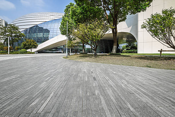 istock Empty square floor and modern city architecture with green trees. 2251351255