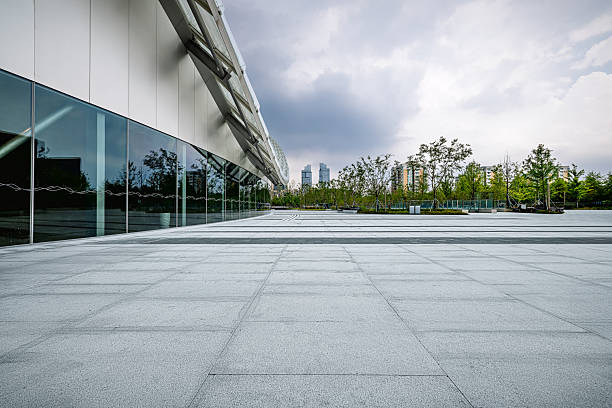 istock Empty square floor and modern glass wall building exterior under cloudy sky. 2251351300