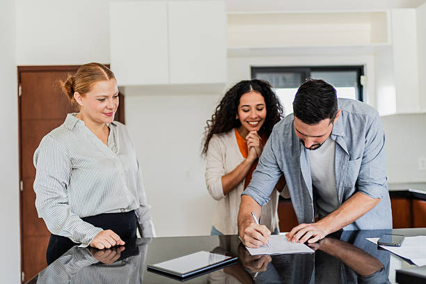 istock Couple signing documents with real estate agent at house 2251351989