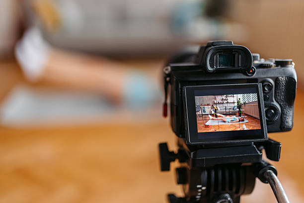 istock Young Woman Filming A Tutorial On Camera While Doing Scissor Kick Exercises At Home 2251354990