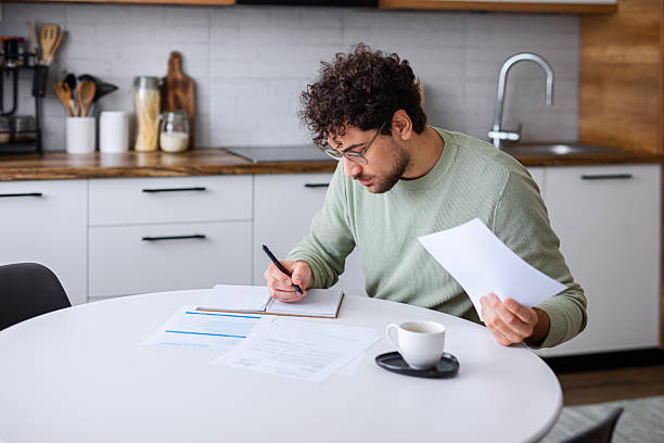 istock Man Analyzing Official Tax Statements at home 2251359870