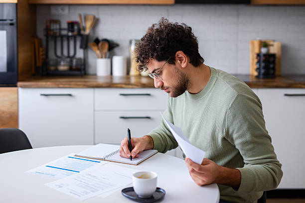istock Man Reviewing Tax Papers and Financial Documents 2251359886